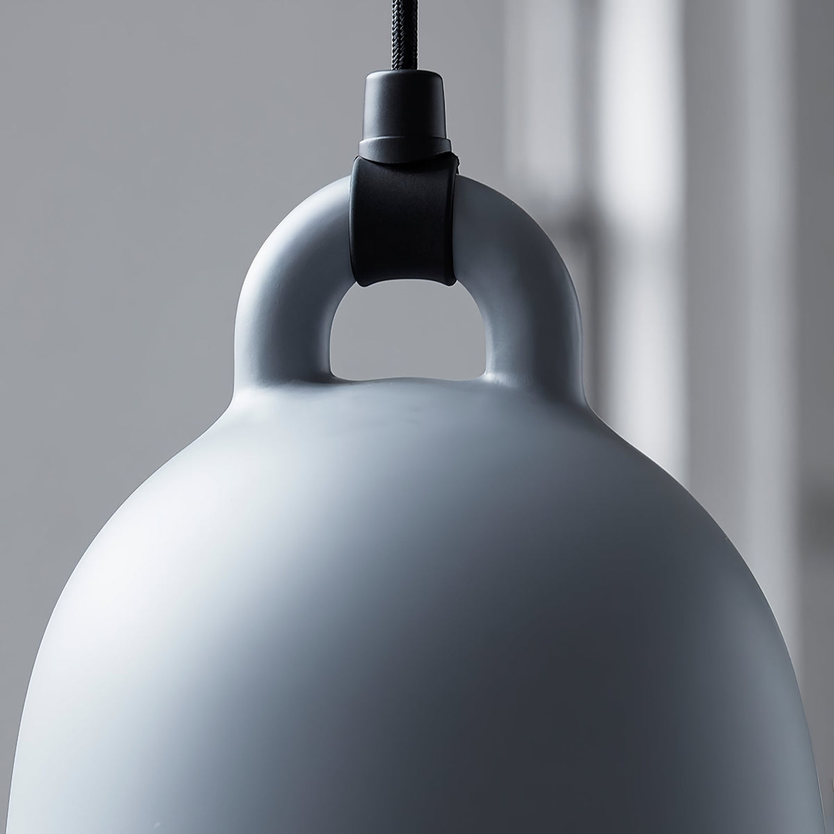 Close view of the loop handle and cord fitting on a grey Clérachic bell pendant, against a soft grey backdrop.