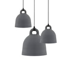 Three grey Clérachic bell pendants in different sizes hang at staggered heights on a plain white backdrop.