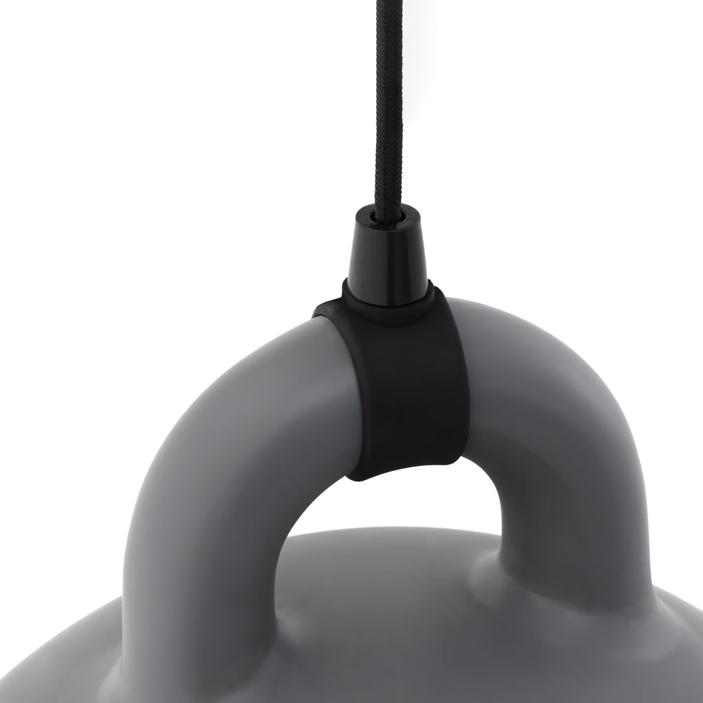 Close view of the black cord grip and handle of a grey Clérachic bell pendant, on a plain white backdrop.