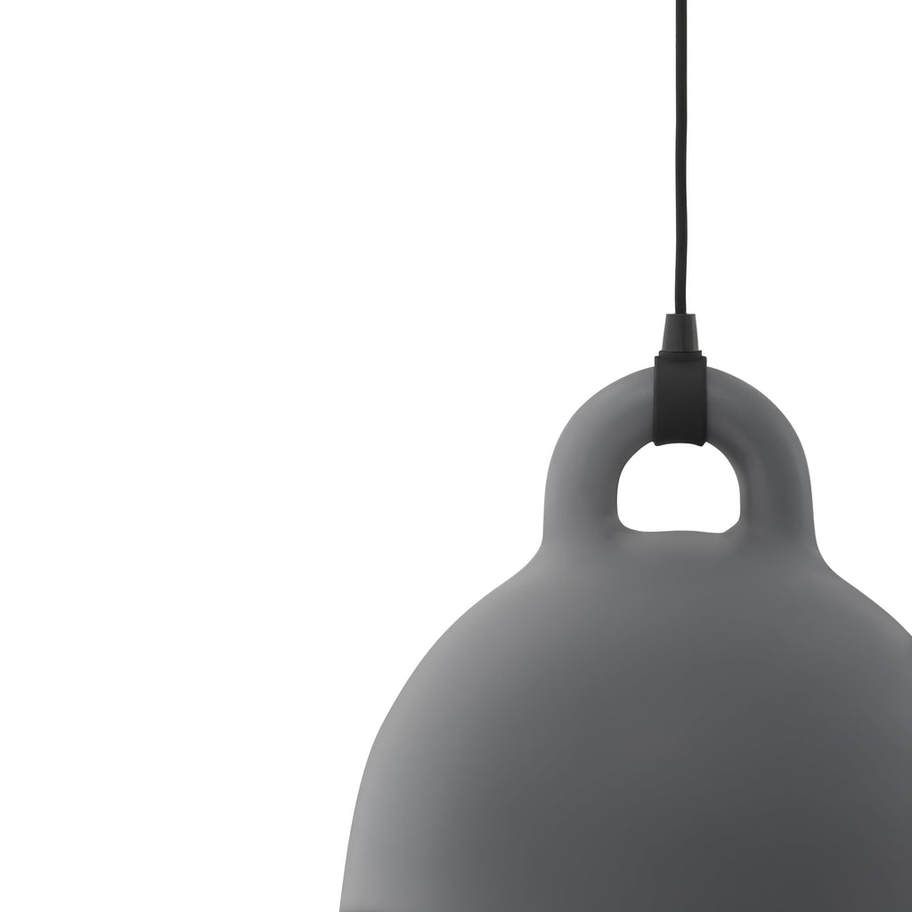 Cropped close view of the loop handle and shoulder of a grey Clérachic bell pendant, with its black cord, on white.