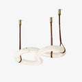 Clérachic Infinity pendant, two interlocking alabaster loops hung from brass fittings on leather straps.