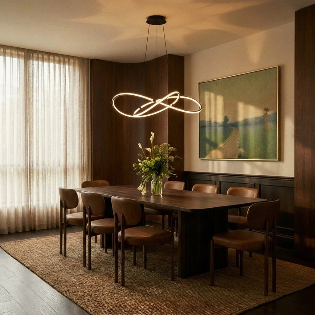 Clérachic black LED loop pendant above a long walnut dining table, set in a warm room with sheer curtains and a landscape painting.