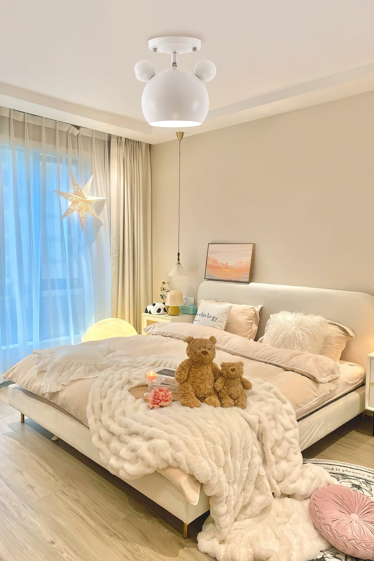 White Clérachic ceiling lamp with round ears above a child-friendly bedroom with a soft throw, teddy bears and blue-lit window.