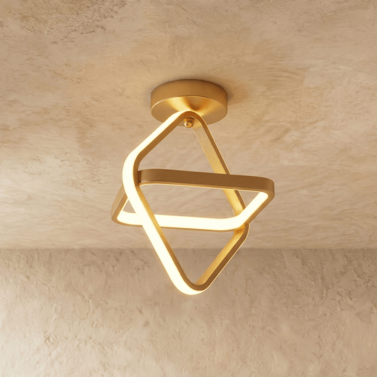 Clérachic brushed gold iron ceiling light of two interlocked tilted squares with a glowing acrylic edge, on limewash plaster.