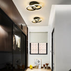 Clérachic two black twin-ring ceiling lights glowing warm along a narrow hallway beside dark wardrobes and a small window.