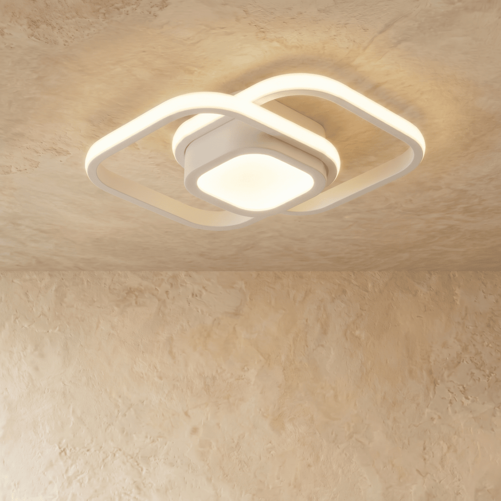 Clérachic white ceiling light with two overlapping rounded-square acrylic loops and a glowing square centre, on plaster.