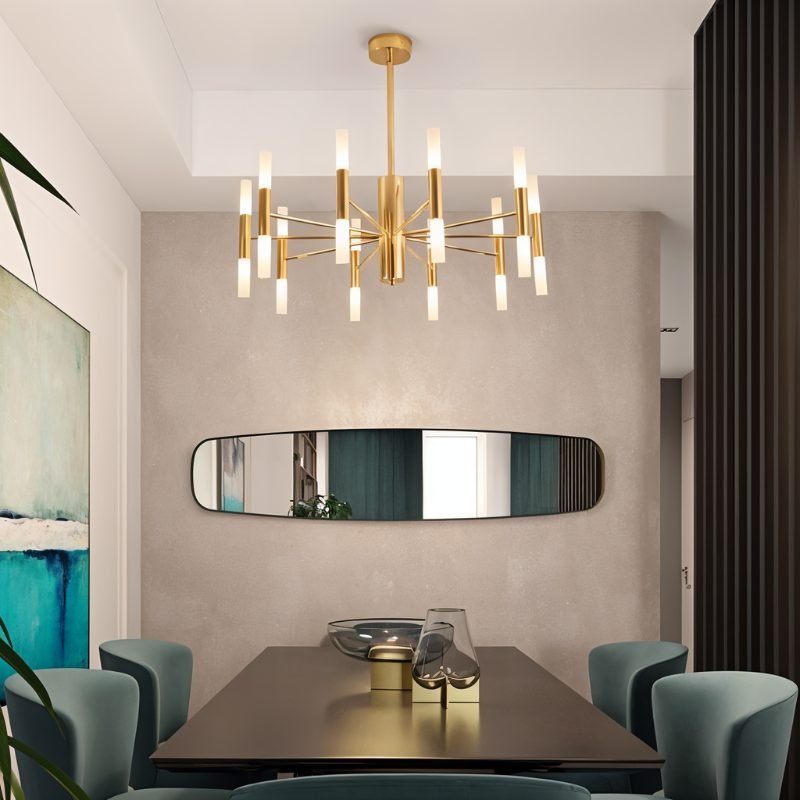 Clérachic brass-gold chandelier with frosted tubes over a dark dining table, a long mirror on the wall behind it.