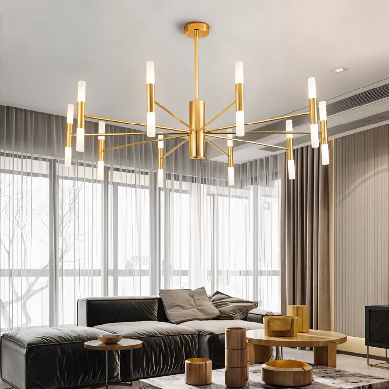 Clérachic gold chandelier with frosted tubes on slim arms above a dark leather sofa and round wooden coffee tables.