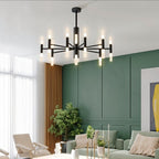 Clérachic black chandelier with a single ring of glowing tubes, hung in a living room with green panelled walls.