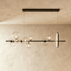 Wider view of the Clérachic bar pendant shows more glass globe bulbs beside the glowing halo disc against plaster.