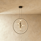 This Clérachic ring pendant clusters several clear glass globe bulbs off-center within its slim black circular frame.