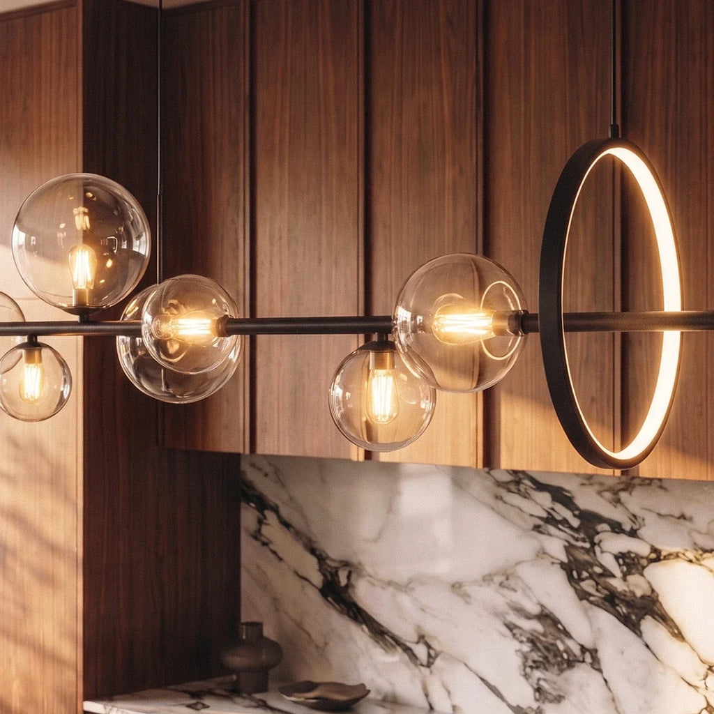 Close-up on the Clérachic pendant's glass globe bulbs and backlit halo disc against walnut cabinetry and marble.