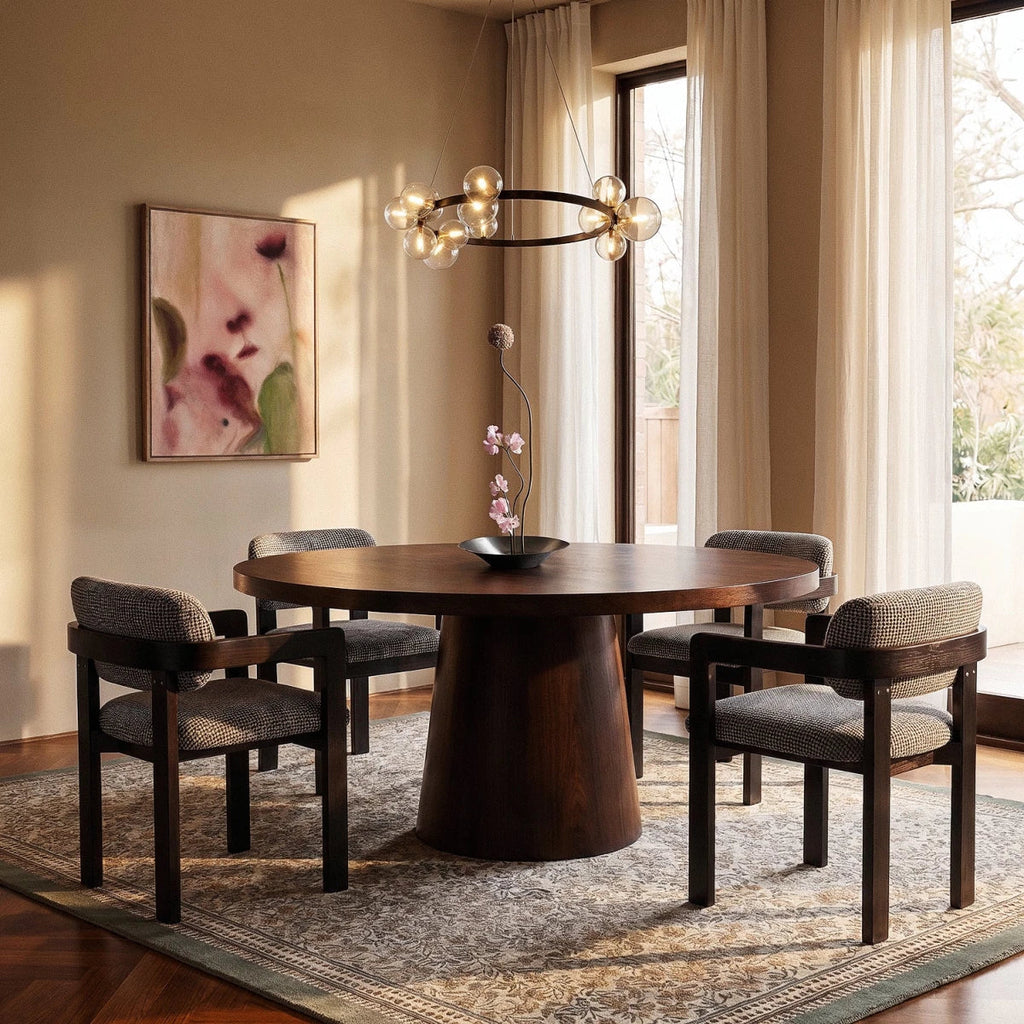 A Clérachic ring chandelier with clustered glass globe bulbs hangs above a round wood dining table and patterned rug.