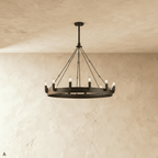 Clérachic compact matte black ring chandelier with candle-style bulbs and fine rods against a limewashed wall.