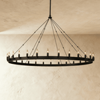 Clérachic extra-wide matte black ring chandelier with two tiers of candle-style bulbs on a slim band, against plaster.