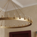 Close view of the Clérachic brass ring chandelier showing its hammered flat band, candle sleeves and clear bulbs.