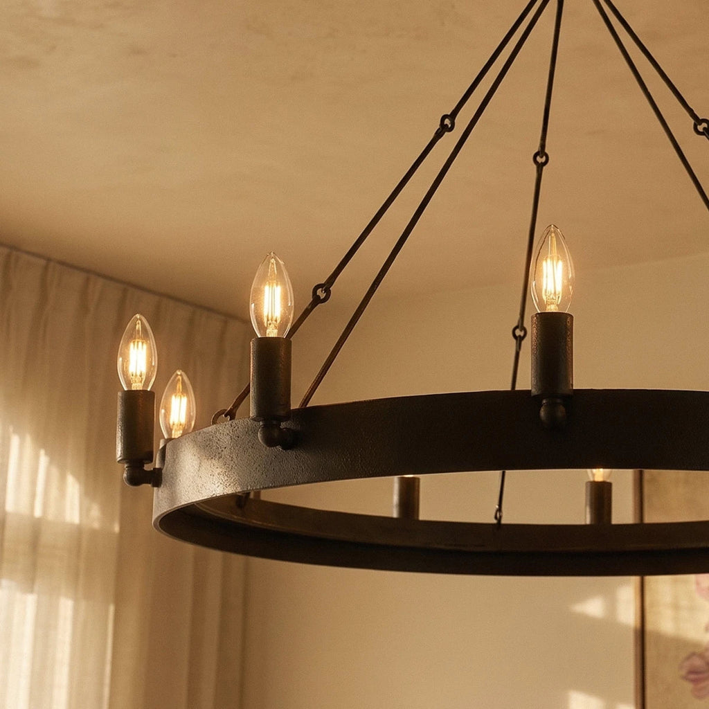 Close view of the Clérachic matte black ring chandelier with textured iron band, candle sleeves and filament bulbs glowing.