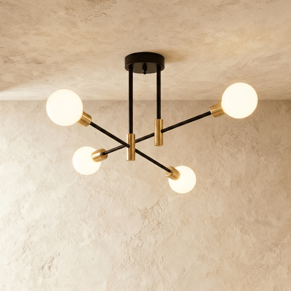 Clérachic 4-arm iron ring chandelier in black with brass sockets, frosted globe bulbs lit against a plaster ceiling.