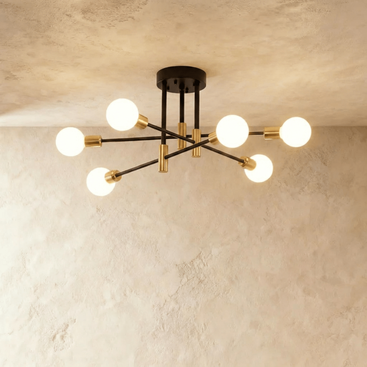 Clérachic 6-arm iron ring chandelier in black with brass sockets, frosted globe bulbs lit against a plaster ceiling.