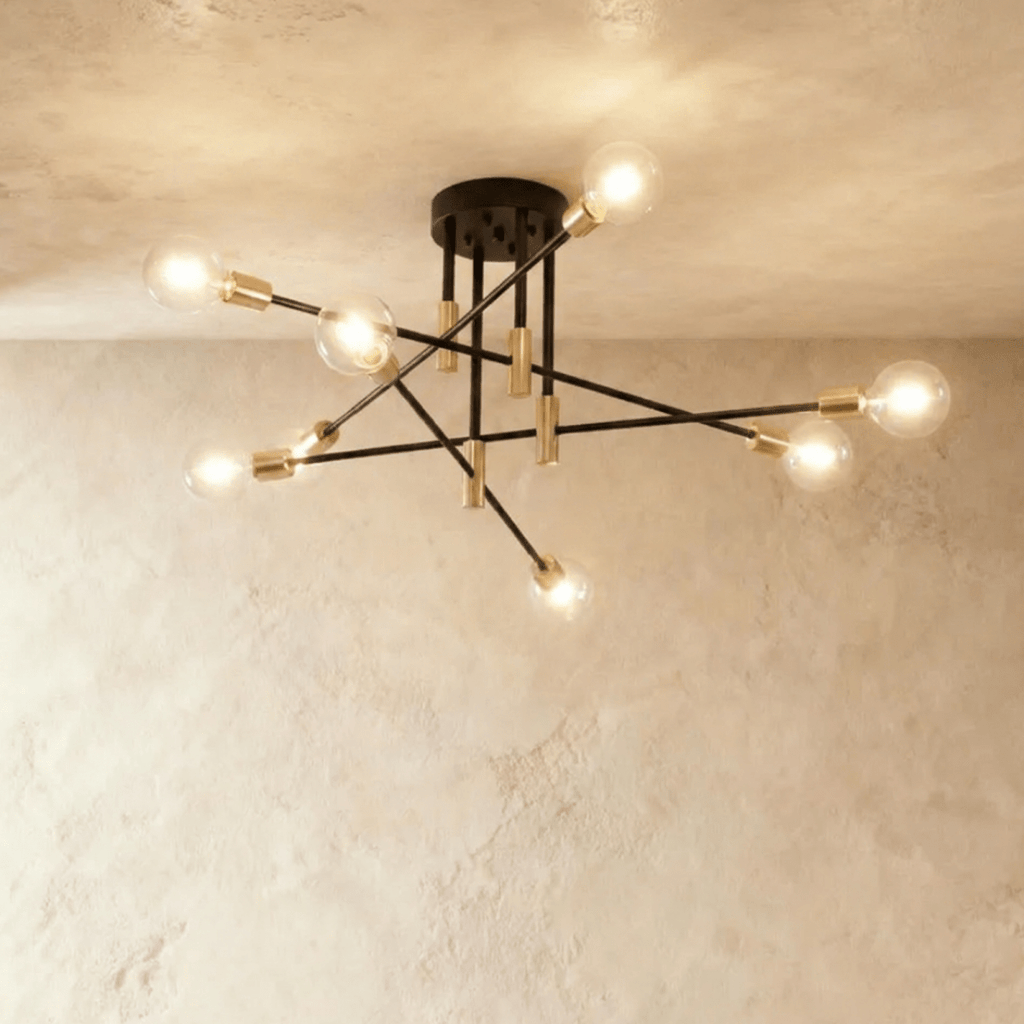 Clérachic 8-arm iron ring chandelier in black with brass sockets, clear filament bulbs lit against a plaster ceiling.