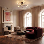 Clérachic 8-arm iron ring chandelier in black and brass, lit above a burgundy sofa and marble fireplace in a living room.