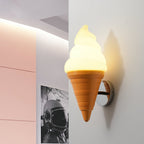 Close angle on a lit Clérachic wall light with an orange cone, beside a pale pink panel and a black-and-white framed print.