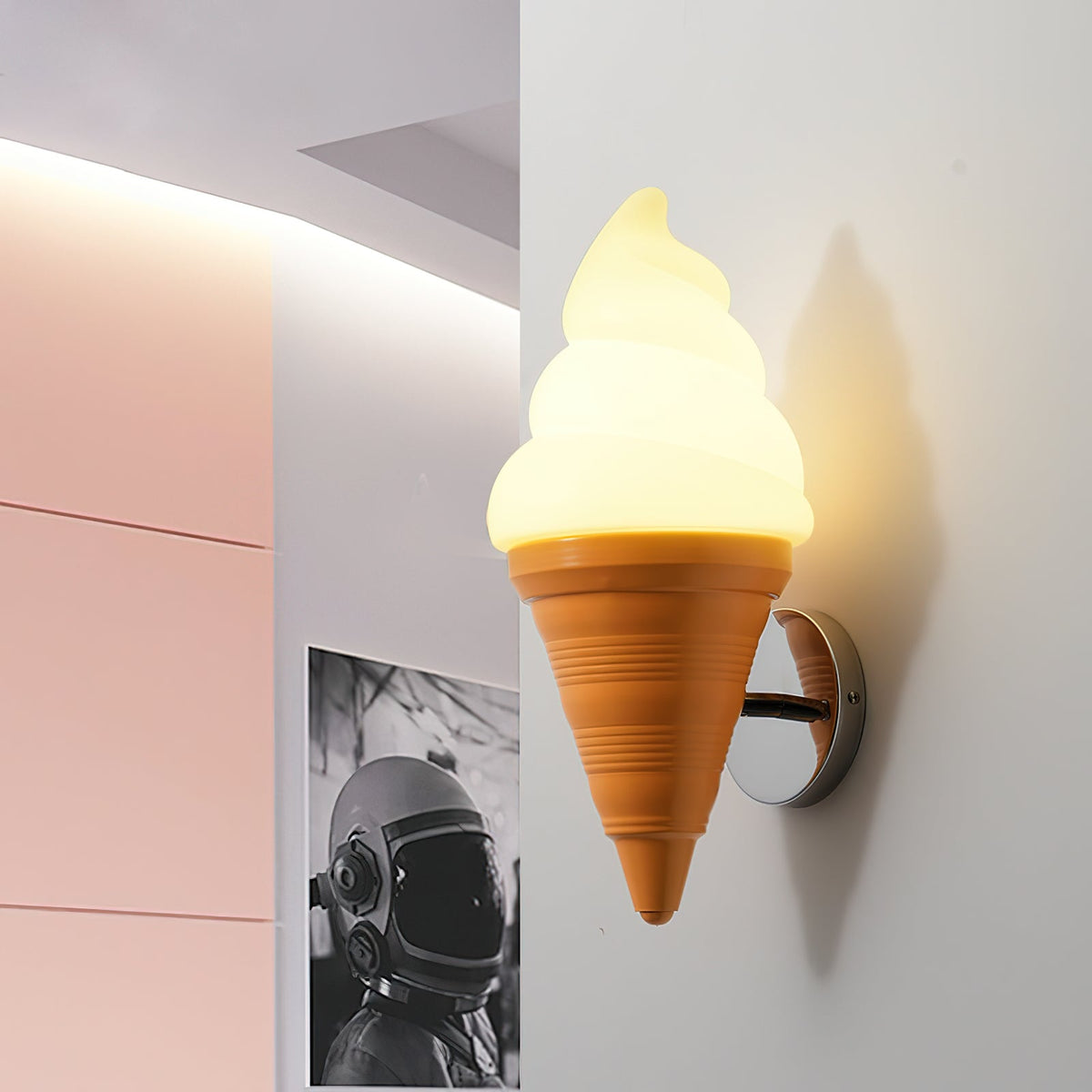Close angle on a lit Clérachic wall light with an orange cone, beside a pale pink panel and a black-and-white framed print.