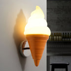 Large view of a lit orange-coned Clérachic wall light on a grey wall, with shelves of bottles blurred in the dark space behind.