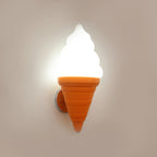 Orange-coned Clérachic wall light switched on against a warm beige wall, the white swirl shade glowing bright with a soft halo.
