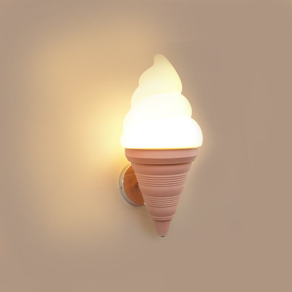 Pink-coned Clérachic wall light lit warm on a dusty rose wall, with a strong amber glow around the swirled shade.