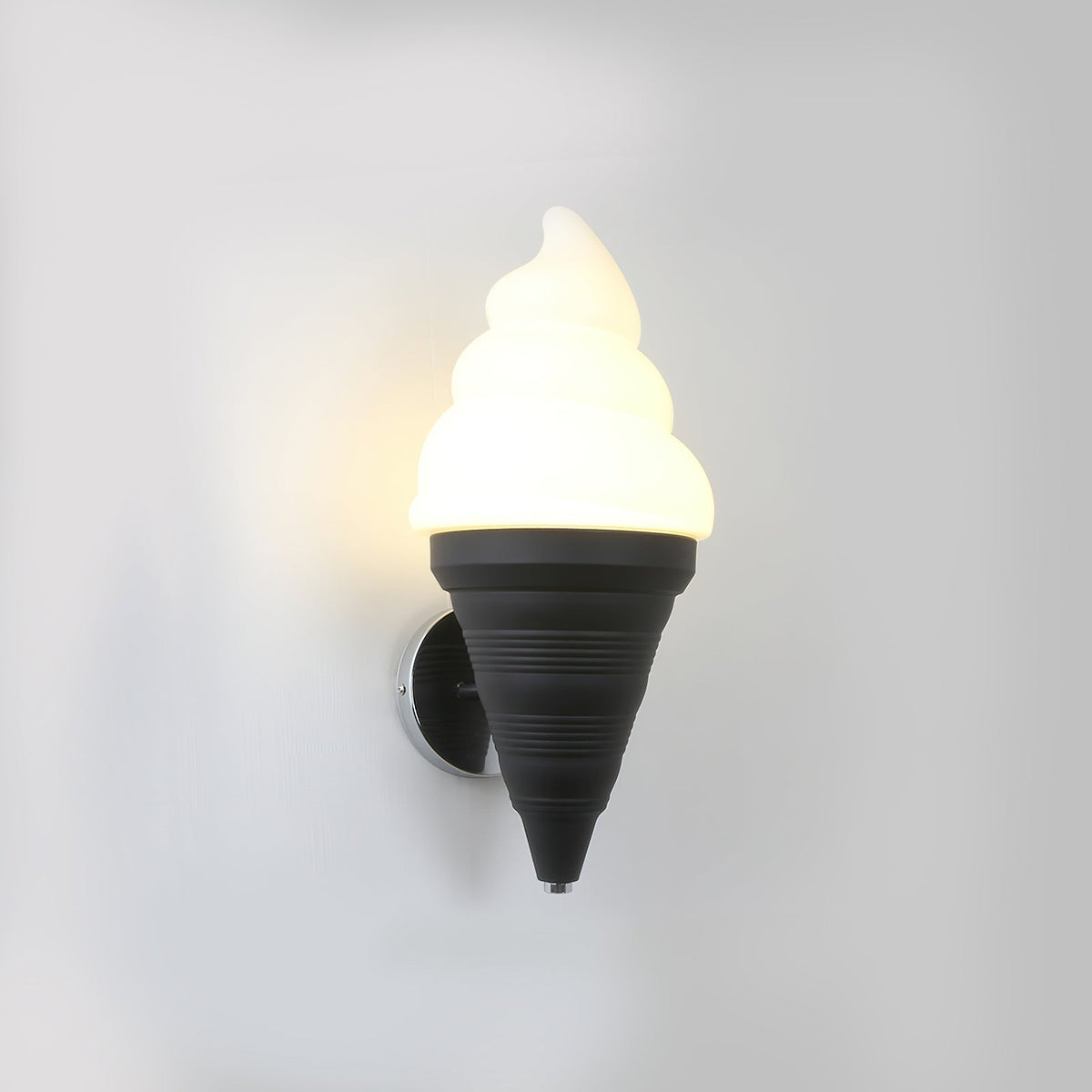 Black-coned Clérachic wall light lit in a warm tone on a light grey wall, the swirl shade glowing above the ribbed cone.