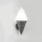 Grey-coned Clérachic wall light lit in cool white on a pale wall, with a ribbed cone and a chrome backplate behind it.