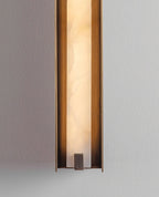 The Clérachic Isolde in close crop, alabaster veining and the bronze end cap set against grey plaster.