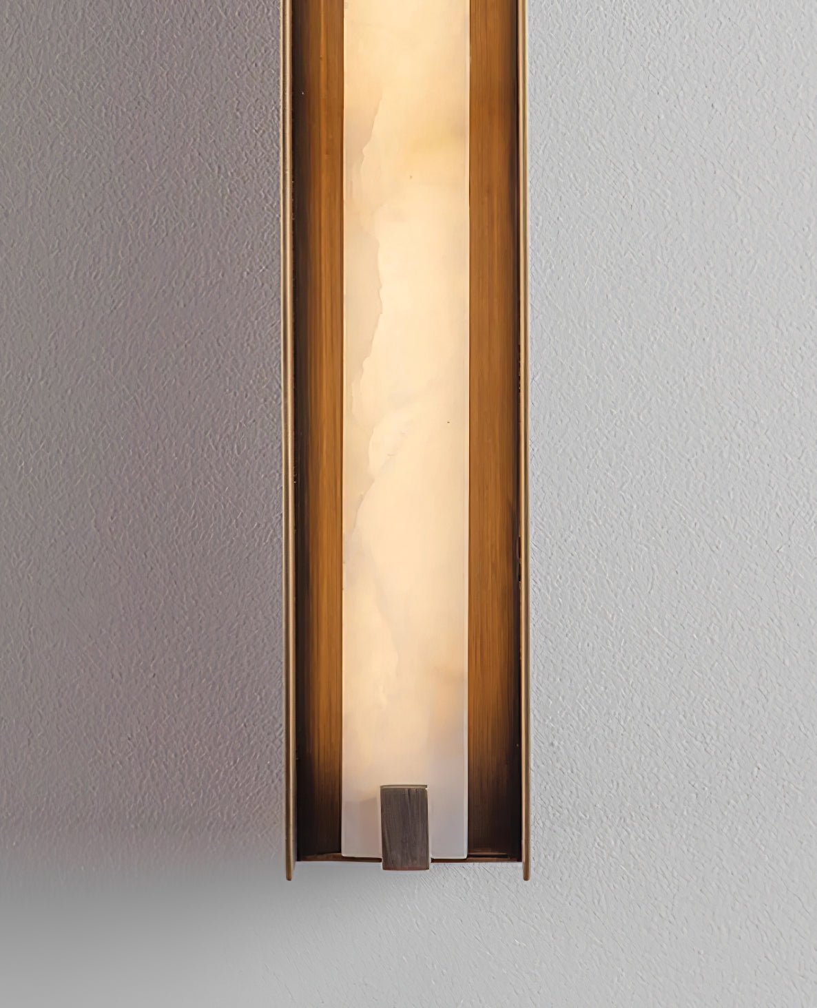 The Clérachic Isolde in close crop, alabaster veining and the bronze end cap set against grey plaster.
