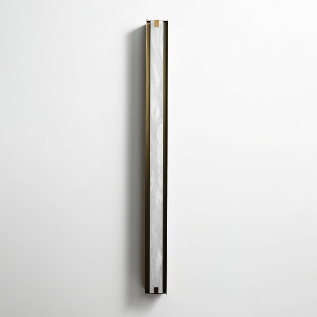 The Clérachic Isolde seen from the side on a pale wall, white alabaster catching light along the bronze edge.