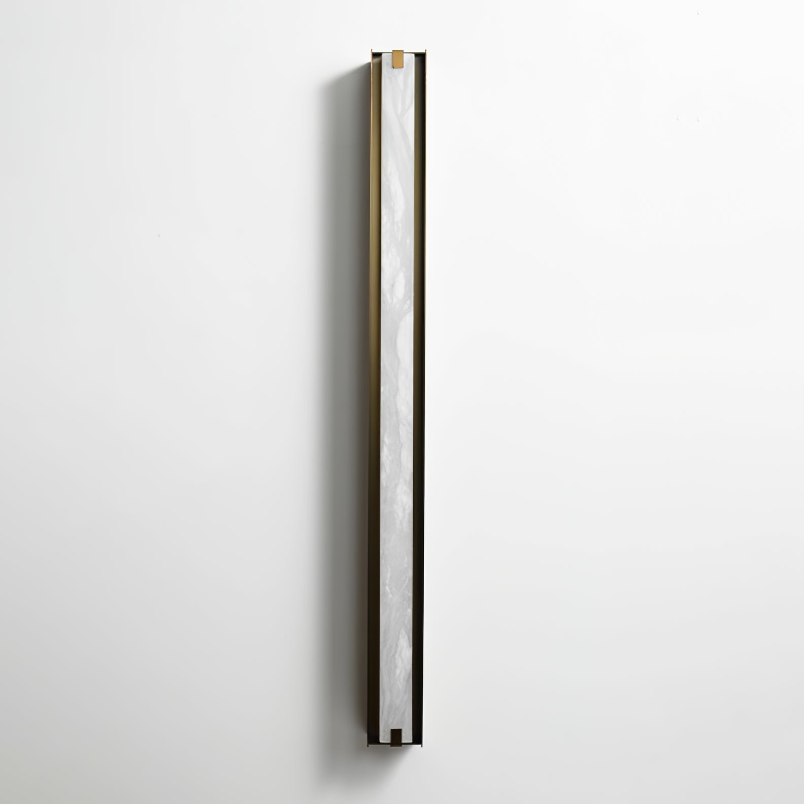 The Clérachic Isolde seen from the side on a pale wall, white alabaster catching light along the bronze edge.