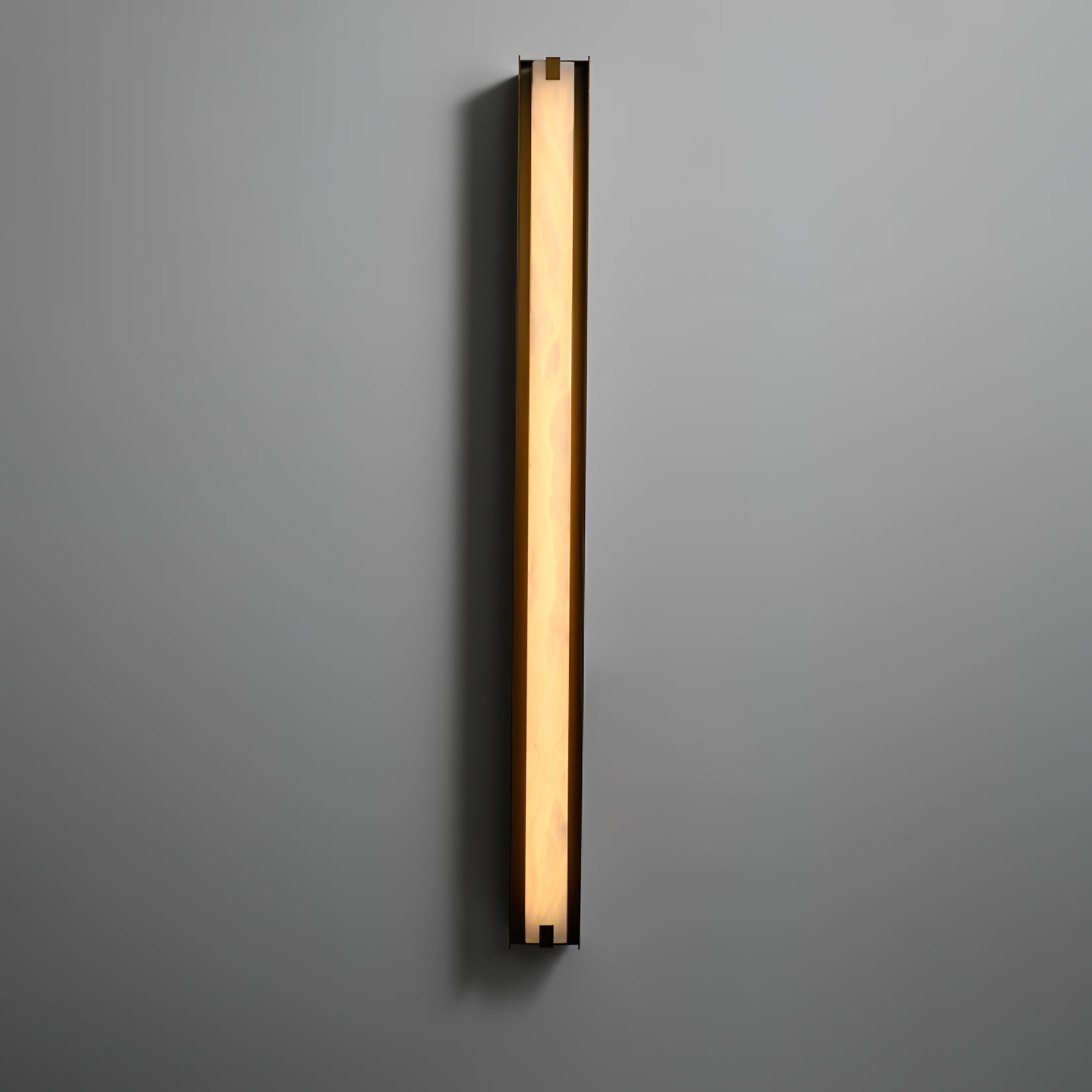 Clérachic Isolde glowing at full length on a soft grey wall, washing warm light up and down the plaster.