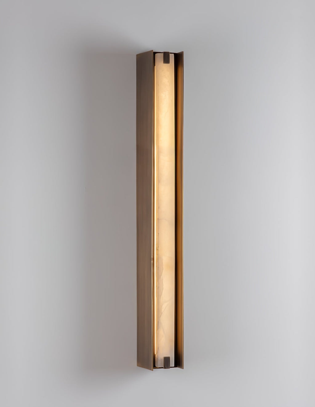 Clérachic Isolde lit against a white wall, close enough to read the grain running through the alabaster.