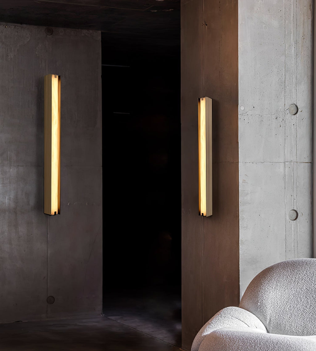 The Clérachic Isolde pair washing warm light down board-marked concrete in a low, shadowed corridor.