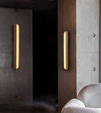 The Clérachic Isolde pair washing warm light down board-marked concrete in a low, shadowed corridor.