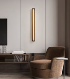 The Clérachic Isolde in a wider room view, lighting the wall panel above a desk and brown armchair.