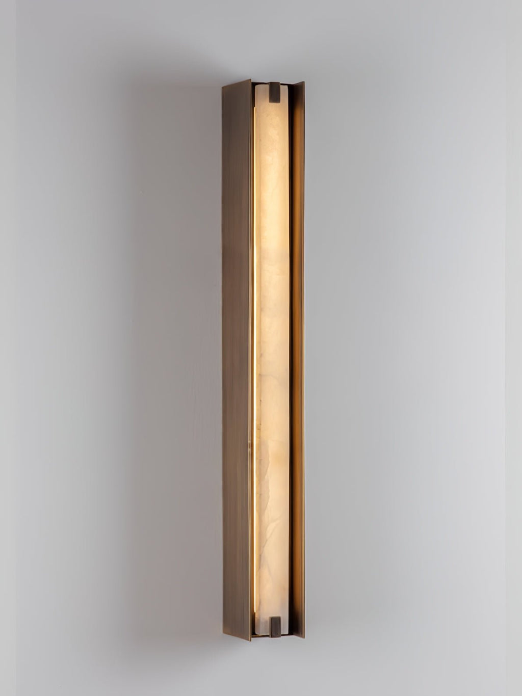 The Clérachic Isolde at a shallow angle on a pale wall, its lit face bright against the bronze frame.