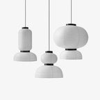 Clérachic paper pendant lamps in three profiles hung at staggered drops, grouped unlit against a pale grey background.