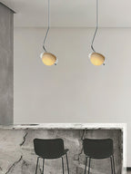 Clérachic Ivvaros pendants hung in a pair above a stone breakfast bar set with two black stools.