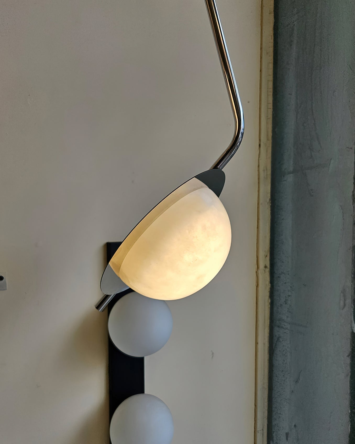 The Clérachic Ivvaros shade tilted on its chrome collar, alabaster veining showing through the lit stone.