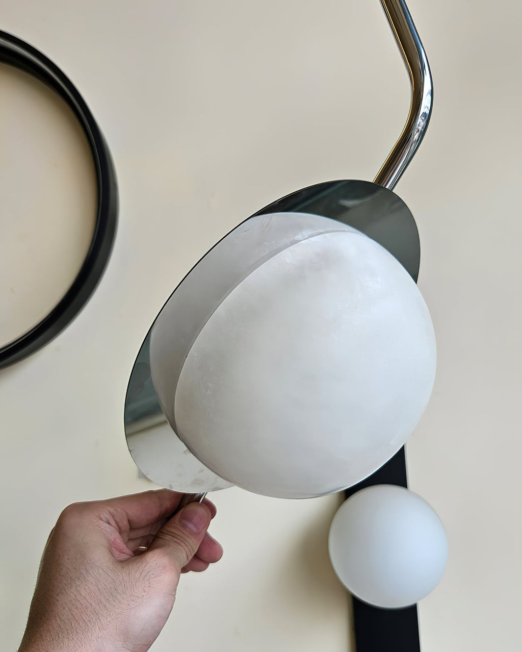Clérachic Ivvaros shade being tilted by hand, showing how the chrome collar swivels to aim the light.