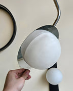 Clérachic Ivvaros shade being tilted by hand, showing how the chrome collar swivels to aim the light.