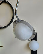 The Clérachic Ivvaros pendant unlit, its pale alabaster dome reading as matte stone beside a round mirror.