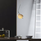 The Clérachic Ivvaros pendant over a kitchen counter, chrome stem curving out from a slim drop cable.