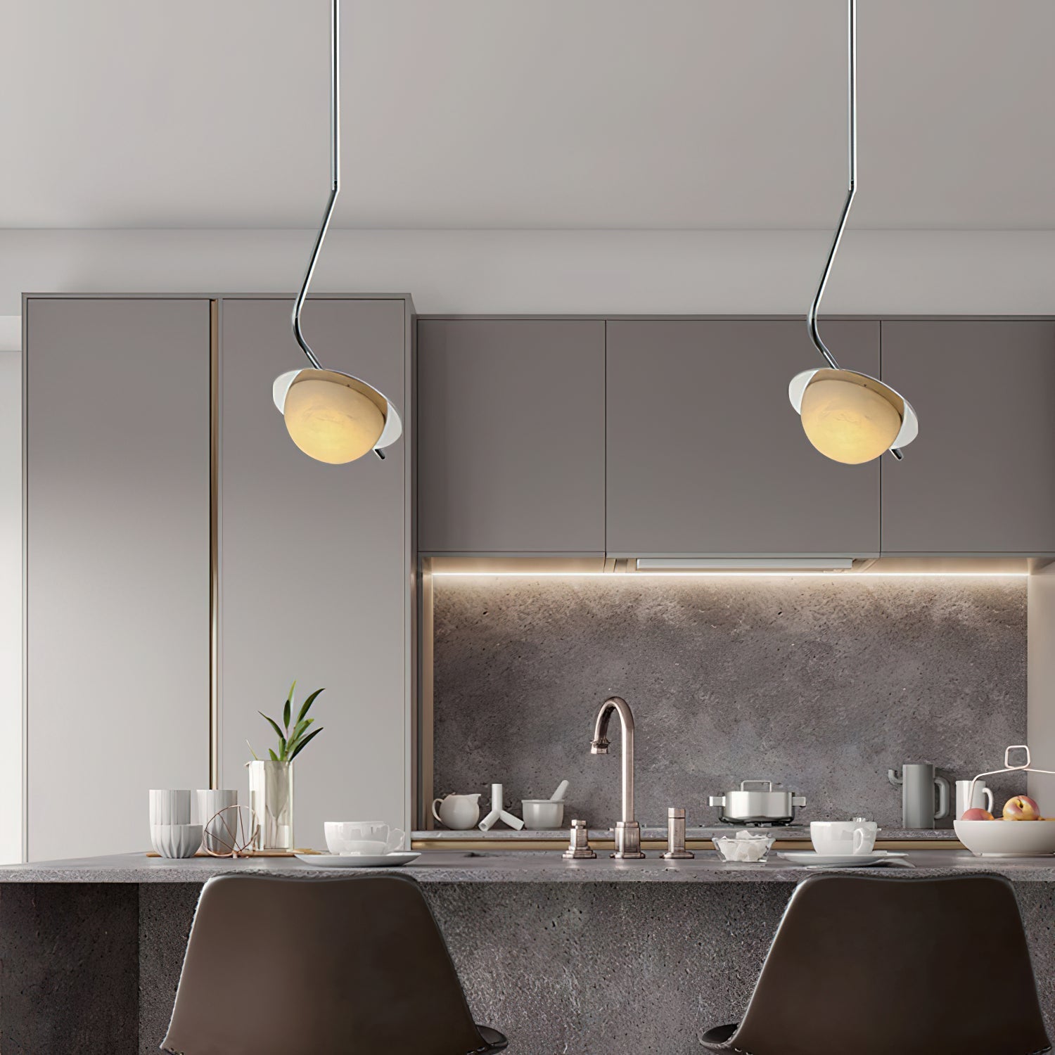 Clérachic Ivvaros pendants paired over a grey kitchen island, each shade angled toward the worktop.